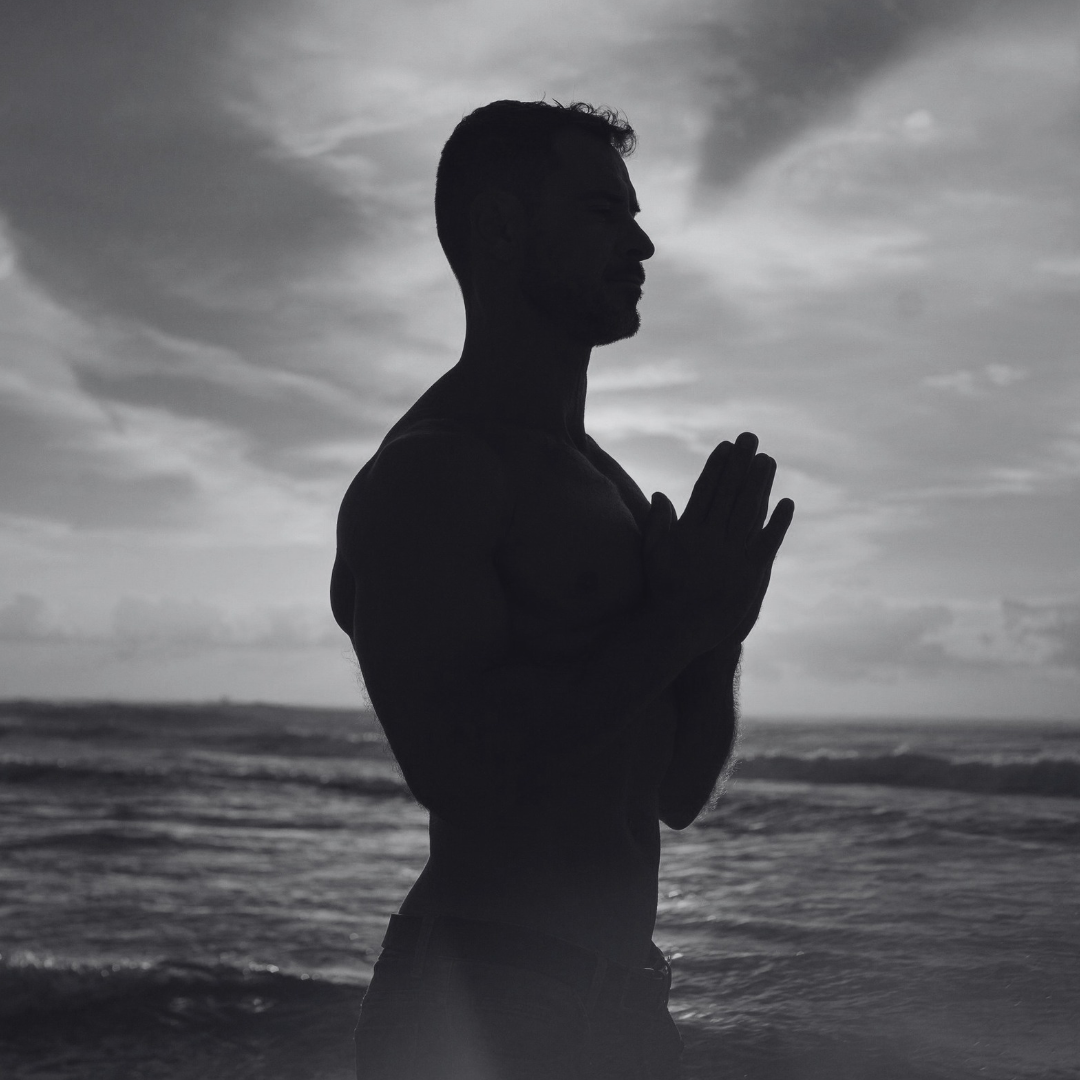 Augusto Penteado em silêncio à beira-mar com as mãos unidas, fotografia em preto e branco