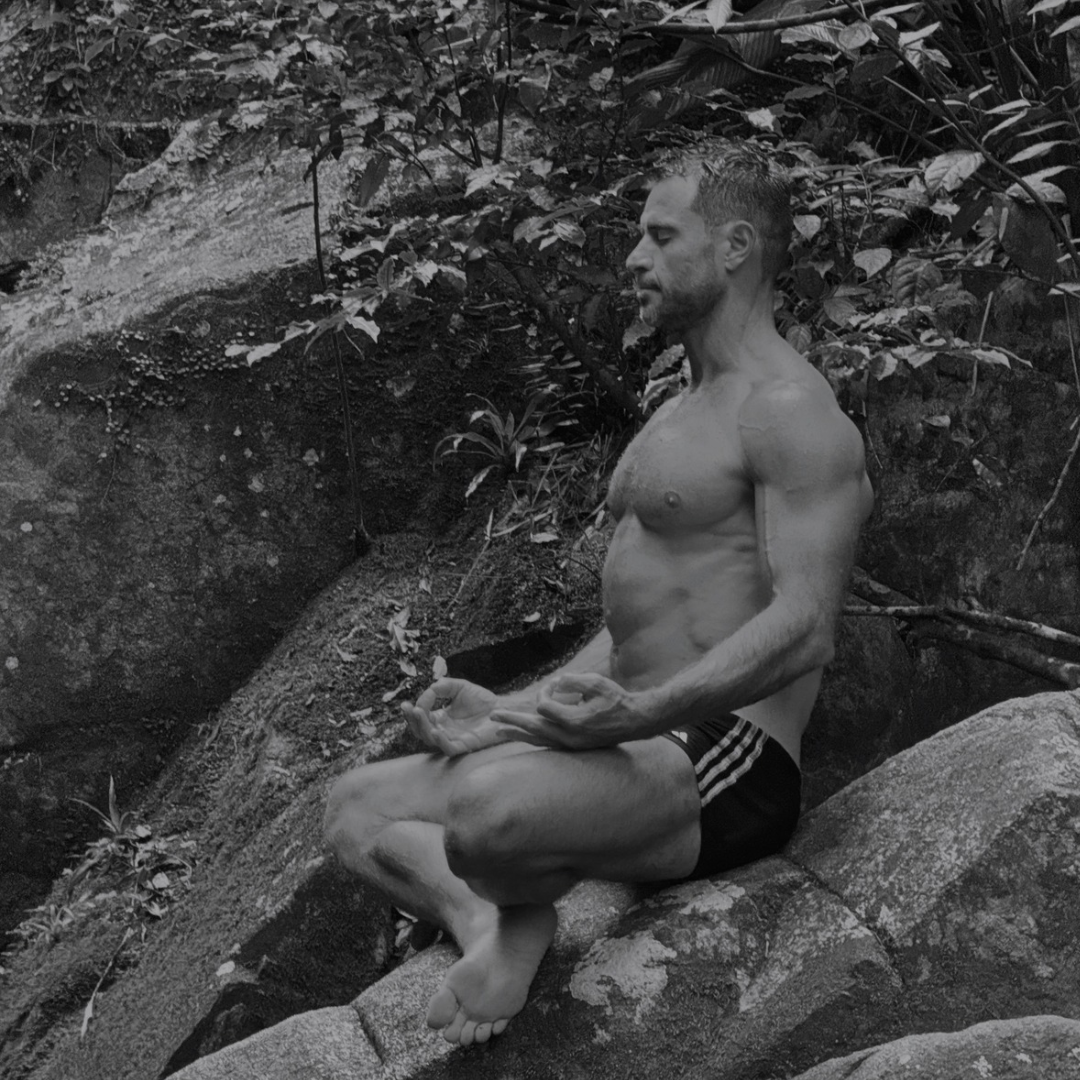 Augusto Penteado em meditação sobre rochas na mata, fotografia em preto e branco